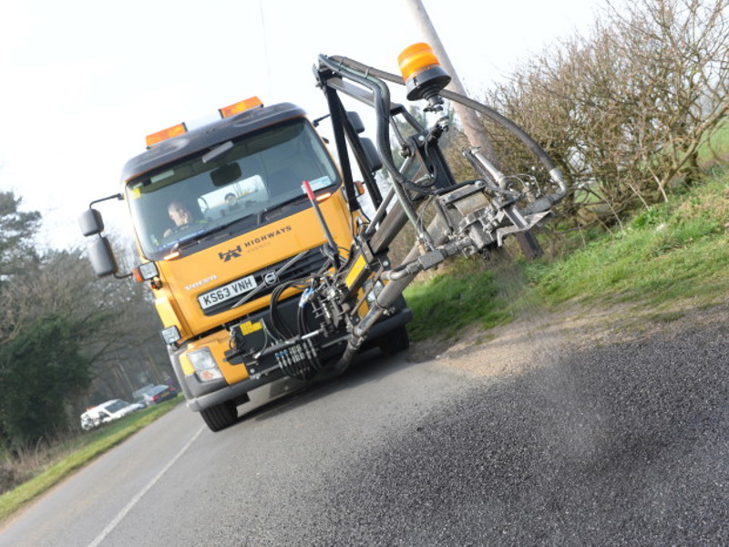 Image of a vehicle, repairing potholes in the road.