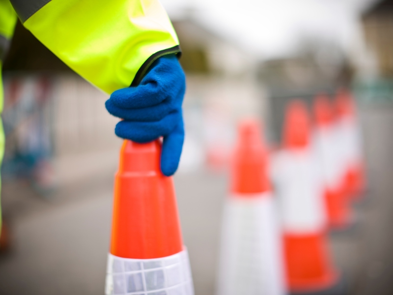 Image a a person holding the top of a traffic cone,
