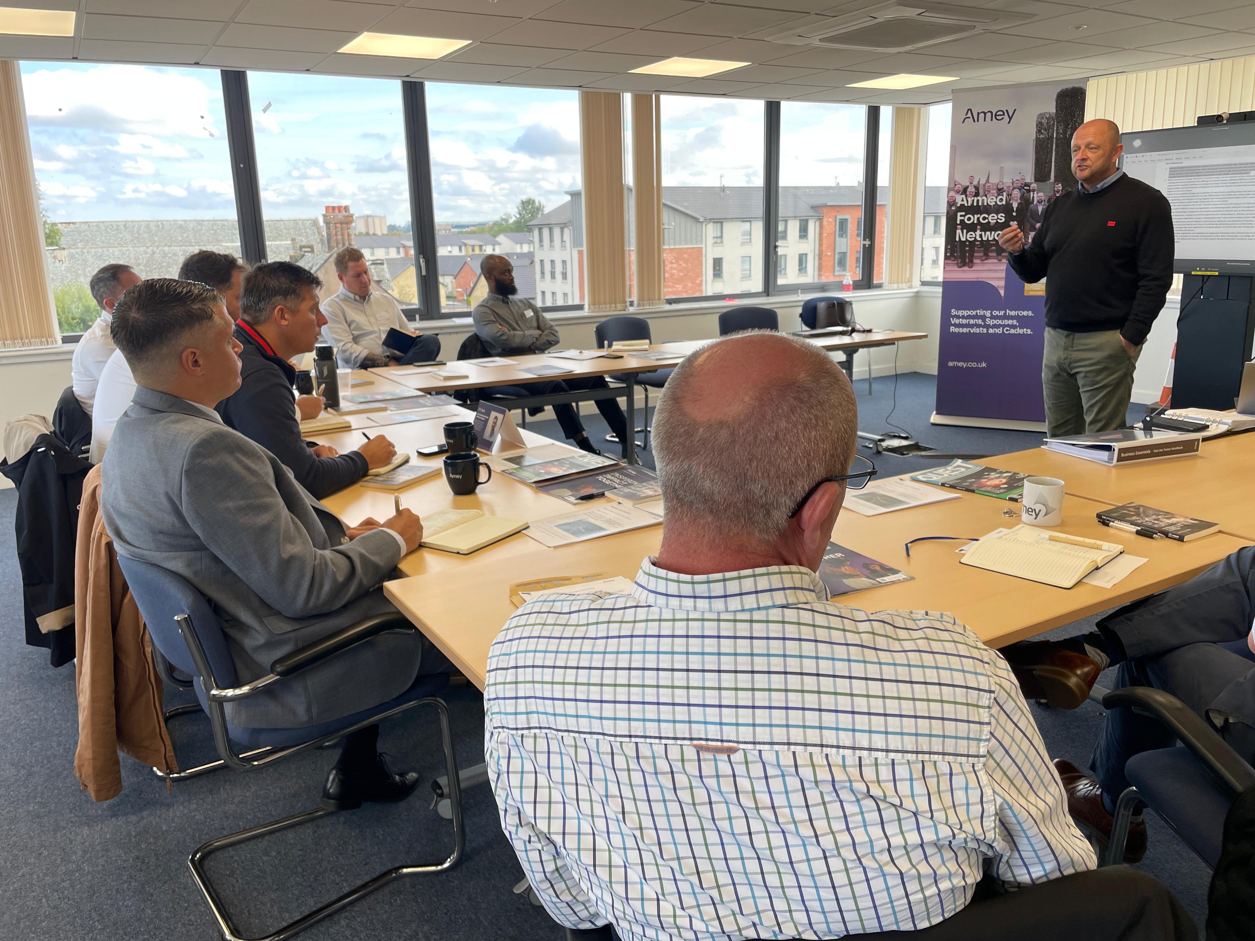 A group of men sitting in a classroom environment