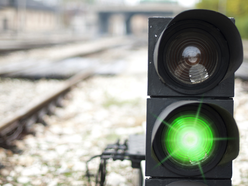 Image of a rail traffic control light on green.