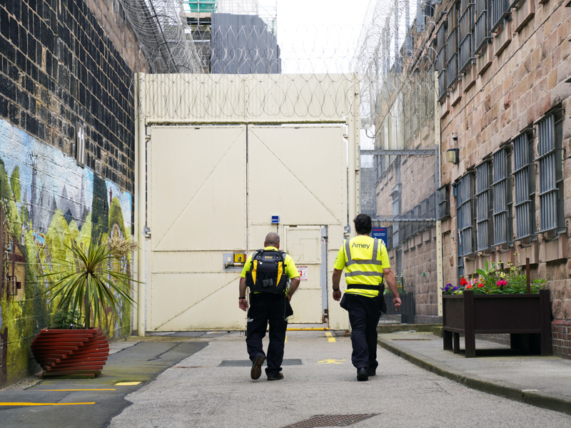 Image of Amey employees walking towards prison