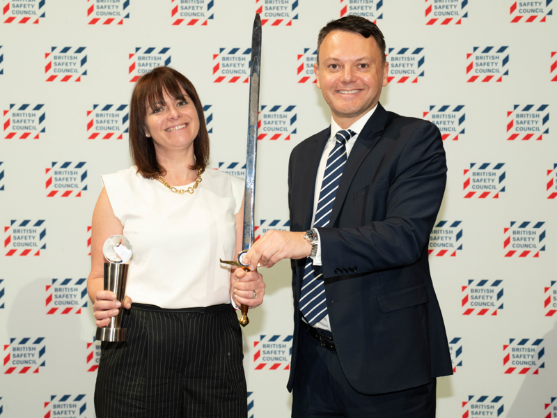 Image of two Amey employees holding an award and a sword.