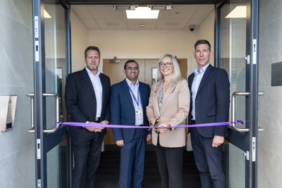 Andy Milner - CEO, and three other people, cutting a purple rope at a new depot.