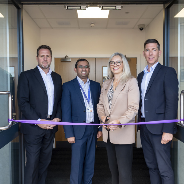 Andy Milner - CEO, and three other people, cutting a purple rope at a new depot.