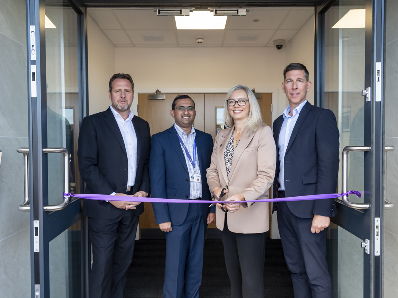 Andy Milner - CEO, and three other people, cutting a purple rope at a new depot.