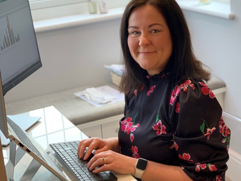Image of a woman at a computer desk.