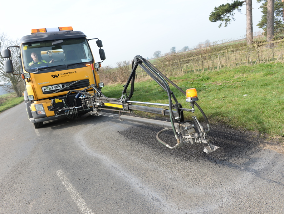 Image of a pothole being repaired using machinery.