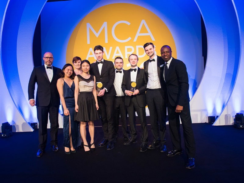 A group of Amey employees, in formal attire, holding an award.