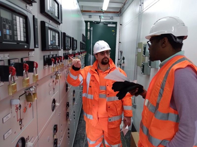 Amey employees wearing PPE, in a control room.