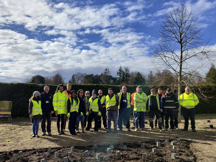 A group of men and women standing together outside in PPE.