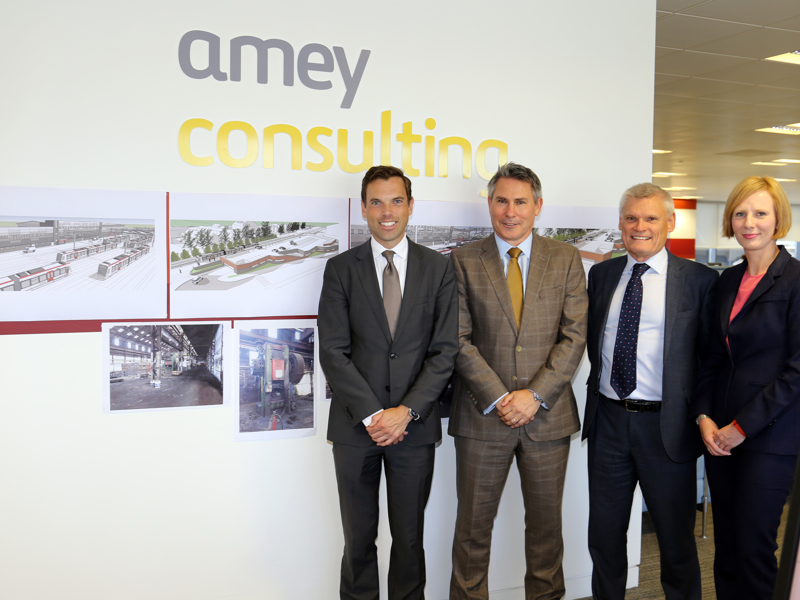 Amey employees, stood in front of an Amey Consulting sign.