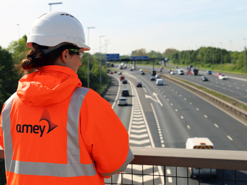 Image of a woman in PPE, overlooking a bridge.