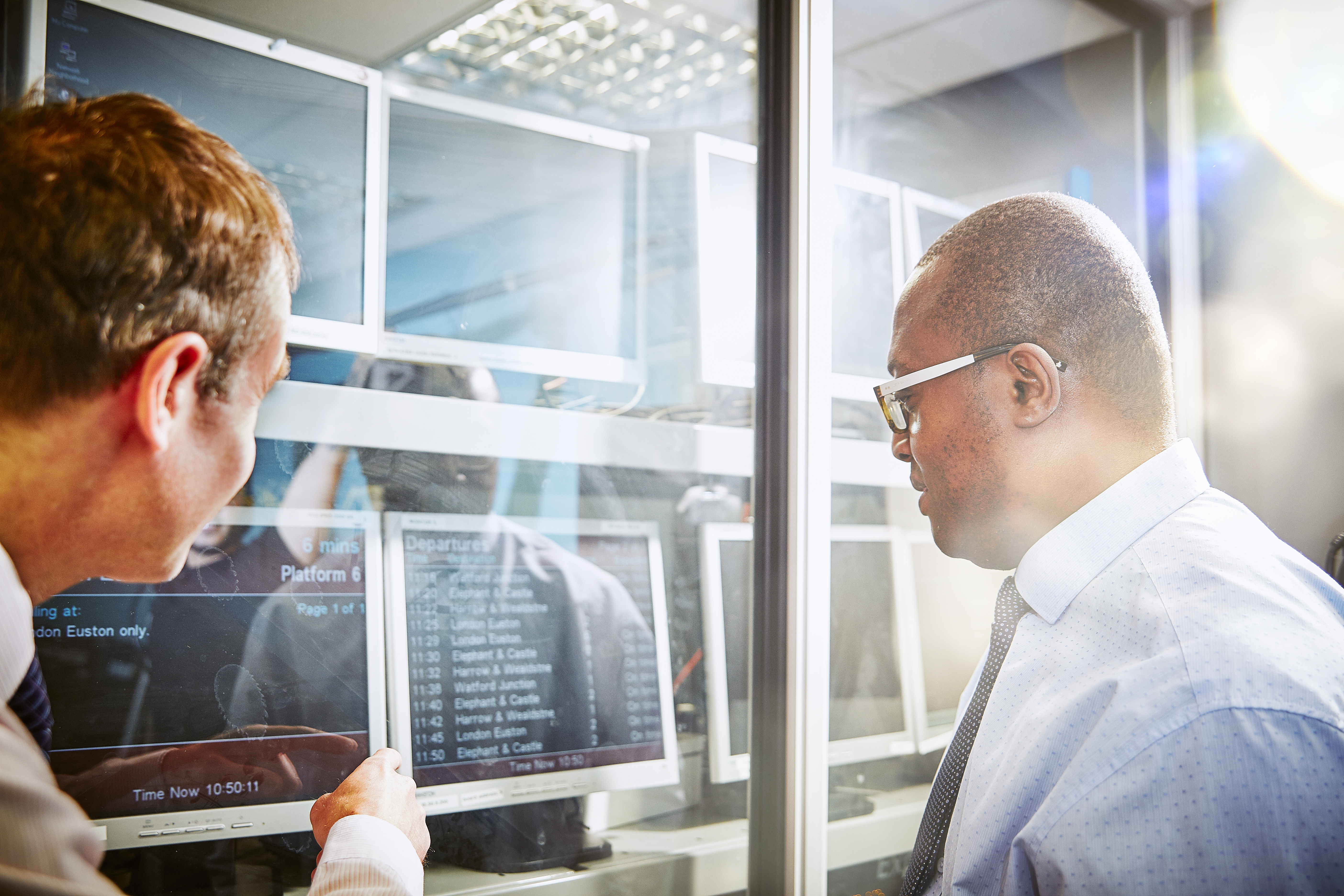 Image of two men looking at a departure board.