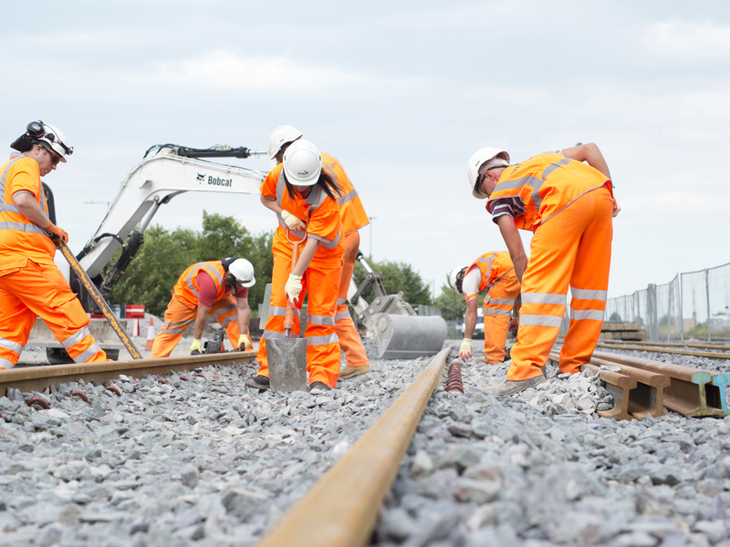 Amey employees, in PPE, working on a rail track.