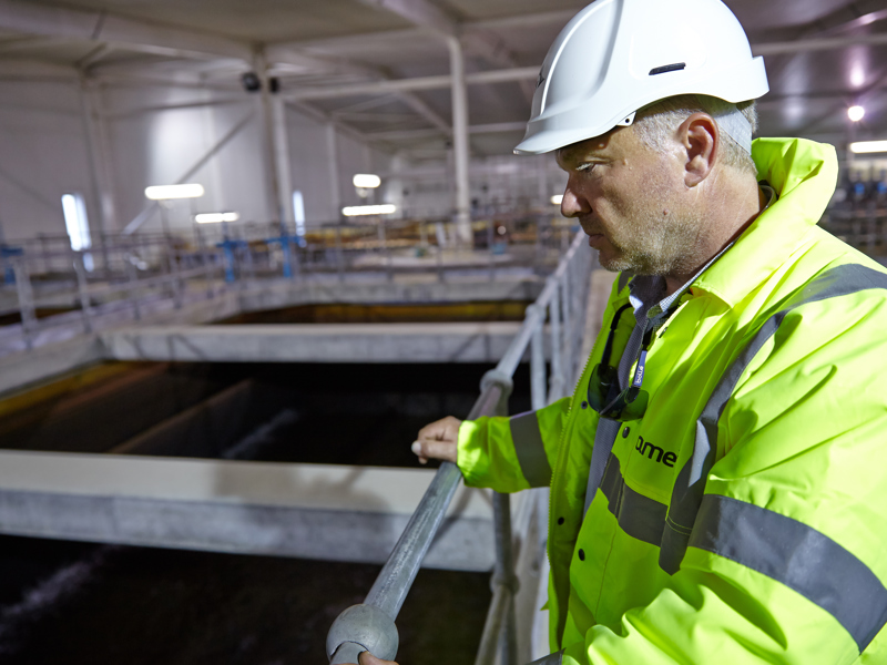 A man in PPE, stood in a water plant warehouse.