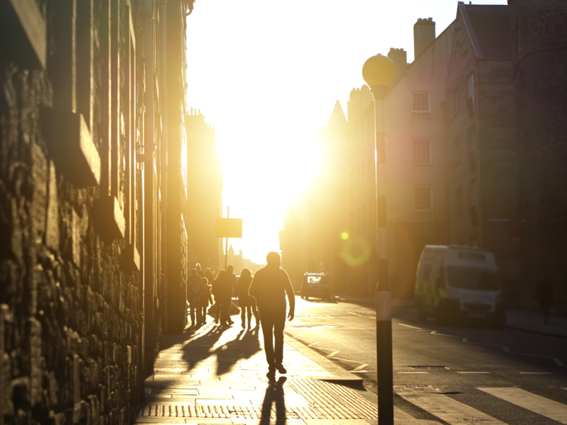 street view of a bright sunrise with shadows cast over the street.