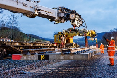 Image of a crane lowering a rail track.