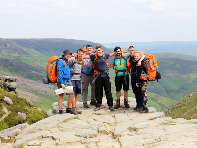 A group of people on a mountain, taking part in the DofE challenge.