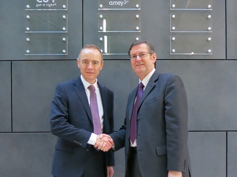 Two men in suits, shaking hands.
