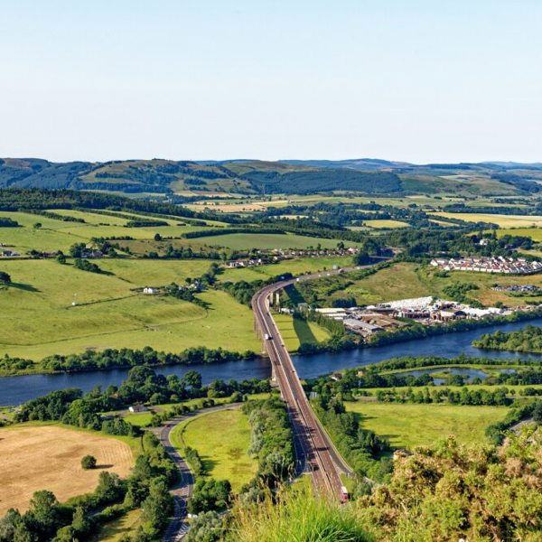 Ariel view of a bridge over a river surrounded by fields.